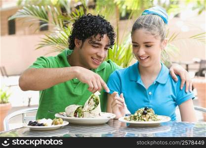 Close-up of a young man and a teenage girl sitting at a table in a restaurant