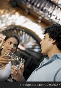 Close-up of a young man and a teenage girl toasting glasses of wine