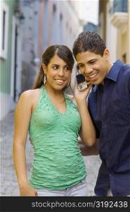 Close-up of a young man and a teenage girl using a mobile phone
