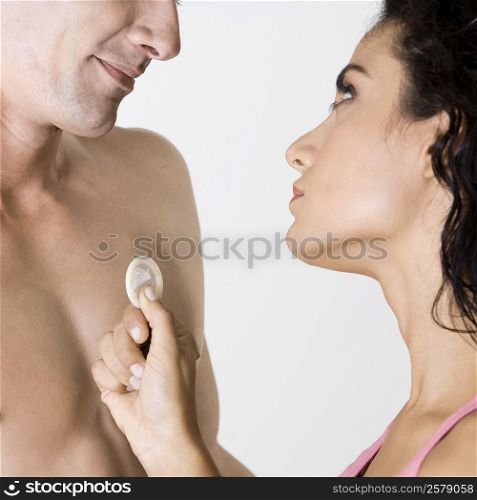 Close-up of a young man and a young woman holding a condom