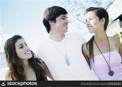 Close-up of a young man and two young women smiling