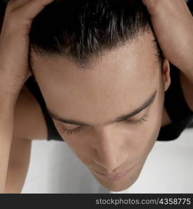 Close-up of a young man applying hair gel