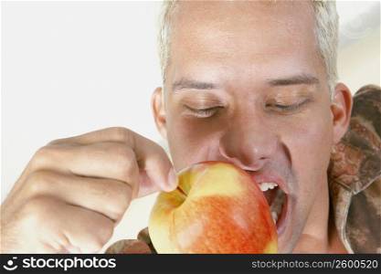 Close-up of a young man biting an apple