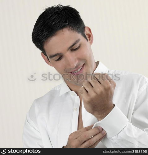 Close-up of a young man buttoning his cuff