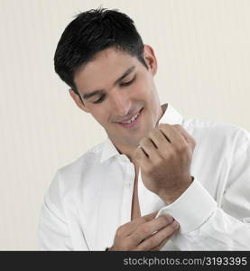 Close-up of a young man buttoning his cuff