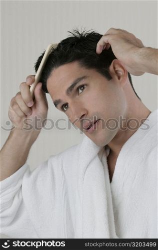Close-up of a young man combing his hair