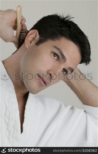 Close-up of a young man combing his hair