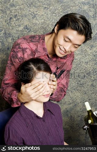 Close-up of a young man covering a young woman&acute;s eyes with his hands