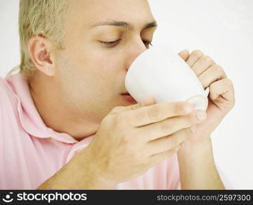 Close-up of a young man drinking coffee from a cup