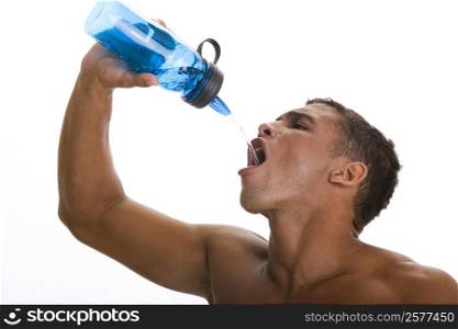 Close-up of a young man drinking water from a bottle