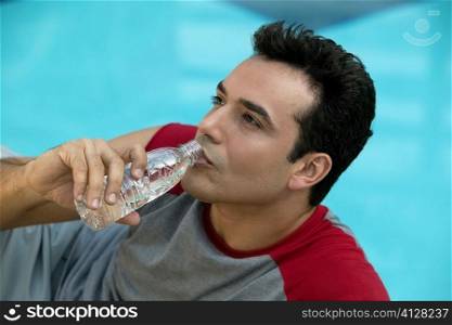 Close-up of a young man drinking water from a water bottle