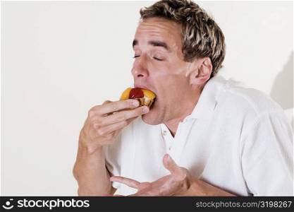Close-up of a young man eating a strawberry tart