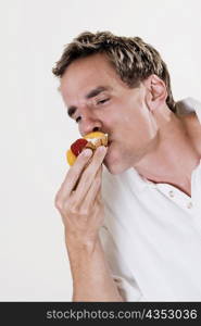 Close-up of a young man eating a strawberry tart