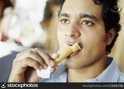 Close-up of a young man eating an ice-cream cone