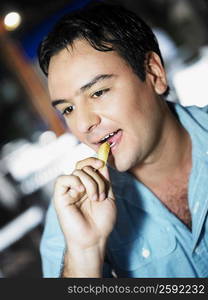 Close-up of a young man eating French fries