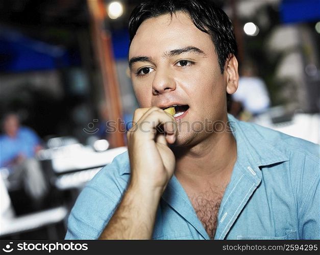 Close-up of a young man eating French fries