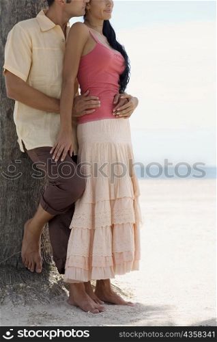 Close-up of a young man embracing a young woman on the beach