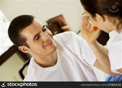 Close-up of a young man feeding a young woman cherries