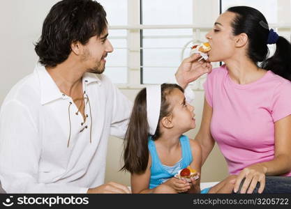 Close-up of a young man feeding pastry to a young woman