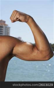 Close-up of a young man flexing his muscles