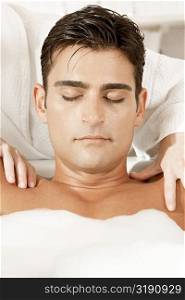 Close-up of a young man getting a massage from a massage therapist