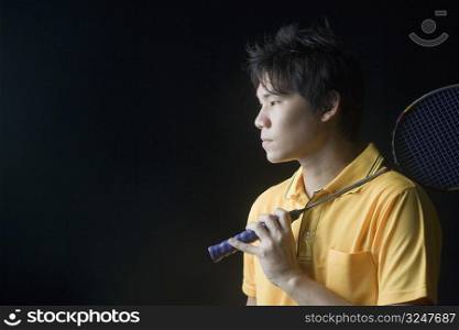 Close-up of a young man holding a badminton racket