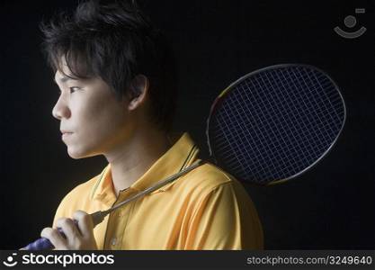Close-up of a young man holding a badminton racket
