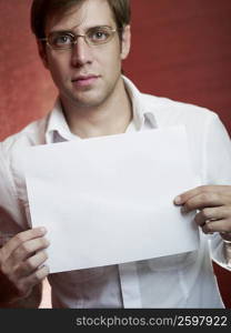 Close-up of a young man holding a blank paper