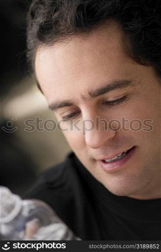 Close-up of a young man holding a bottle of water