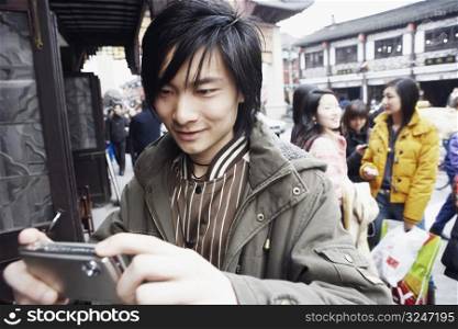 Close-up of a young man holding a camera smiling