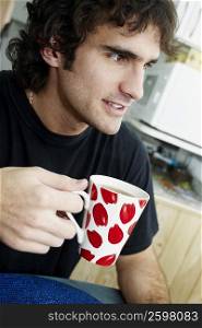 Close-up of a young man holding a cup of tea