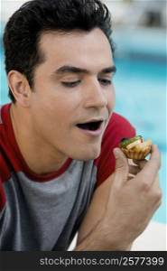 Close-up of a young man holding a cupcake