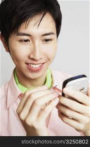 Close-up of a young man holding a digitized pen and a mobile phone