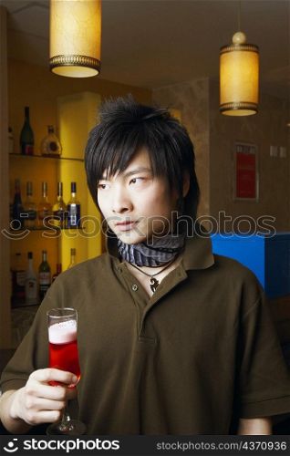 Close-up of a young man holding a glass