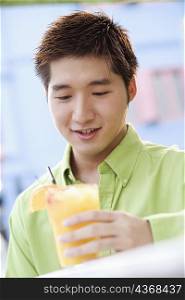 Close-up of a young man holding a glass of juice