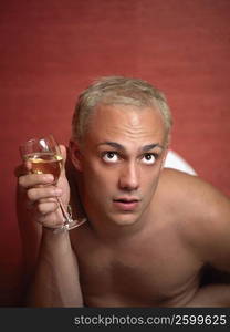 Close-up of a young man holding a glass of wine