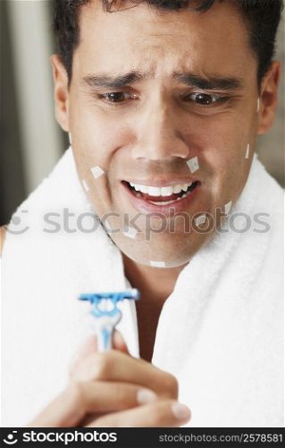 Close-up of a young man holding a razor