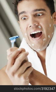 Close-up of a young man holding a razor