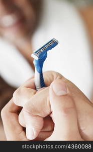 Close-up of a young man holding a razor