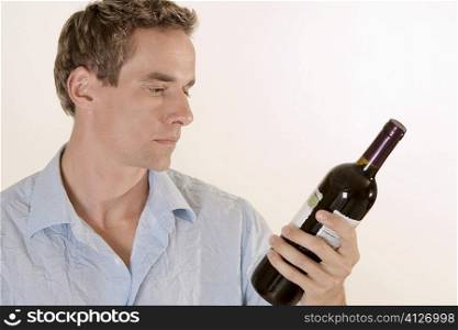 Close-up of a young man holding a wine bottle