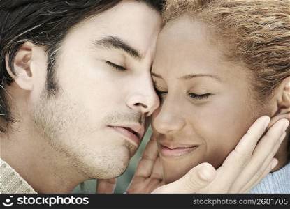 Close-up of a young man holding a young woman&acute;s face