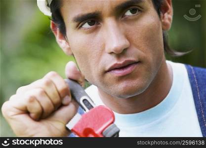Close-up of a young man holding an adjustable wrench