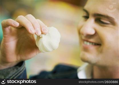 Close-up of a young man holding garlic