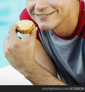 Close-up of a young man holing a lime tart