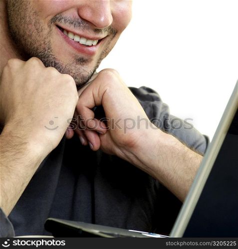 Close-up of a young man in front of a laptop