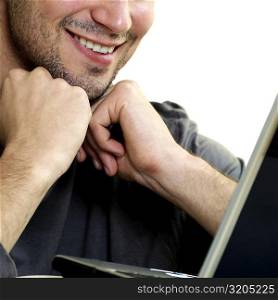 Close-up of a young man in front of a laptop