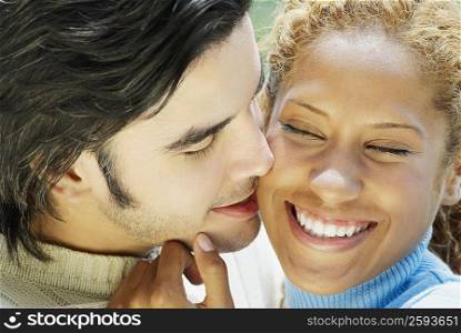 Close-up of a young man kissing a young woman