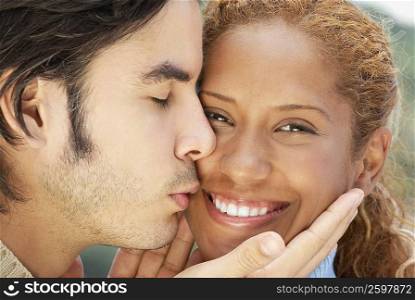 Close-up of a young man kissing a young woman