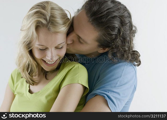 Close-up of a young man kissing a young woman