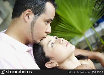Close-up of a young man kissing a young woman on her forehead